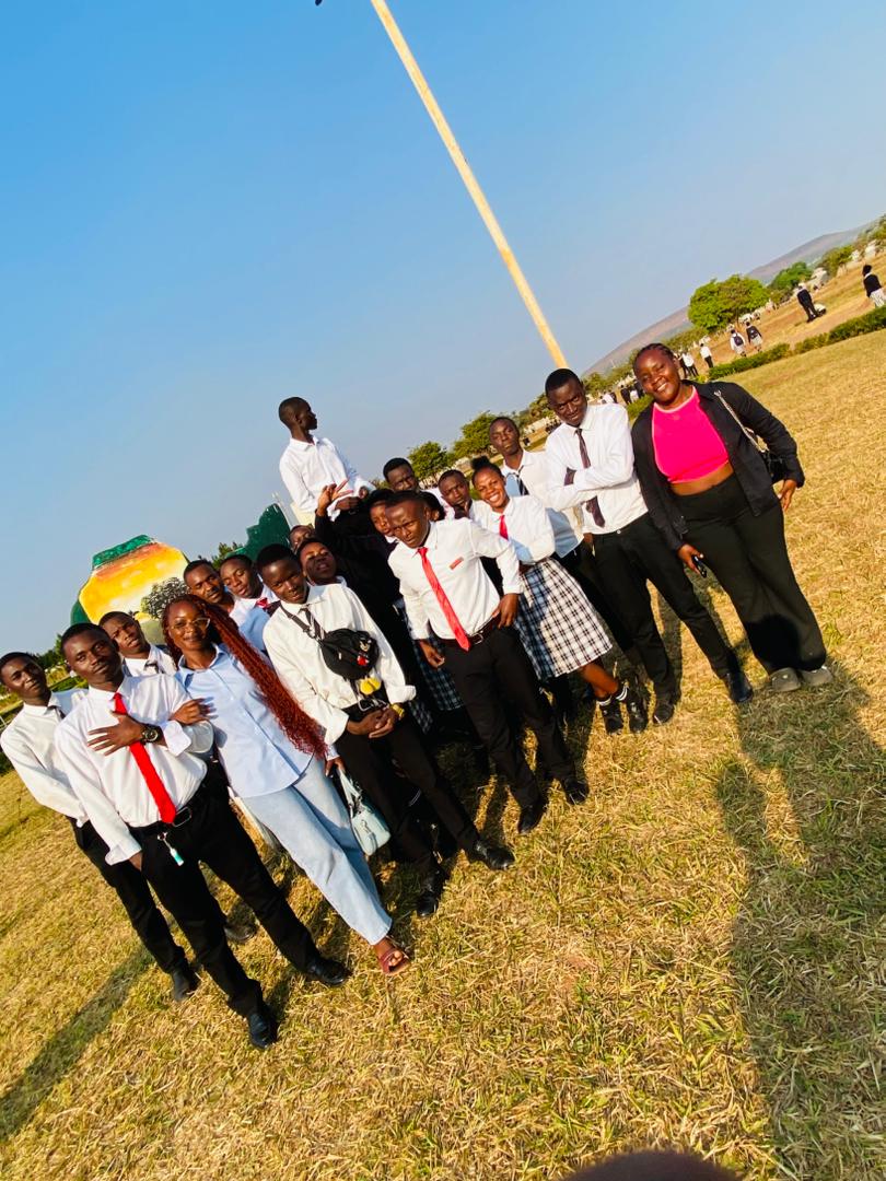 Forge Ambassadors with students on the school grounds in Kasama