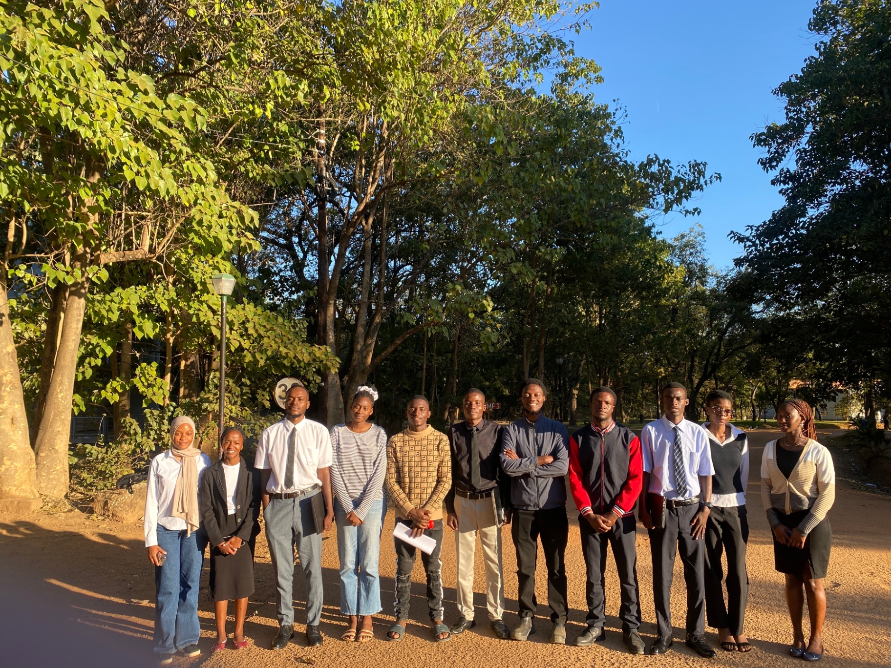 THE FORGE cohort gathered under campus trees at golden hour