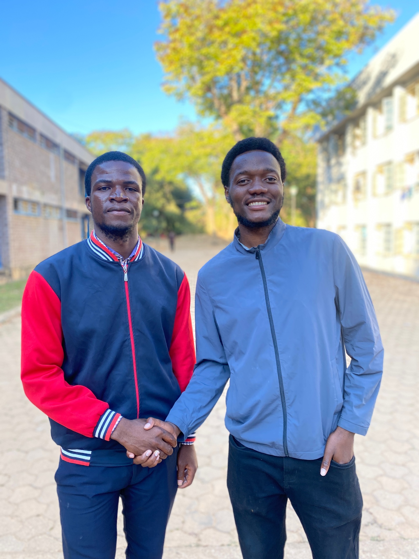 Two FORGE members exchanging a handshake on campus