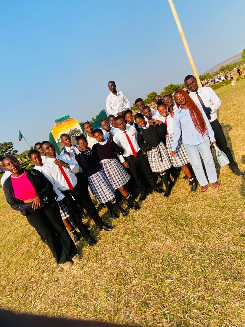 Forge Ambassadors with students on the school grounds in Kasama